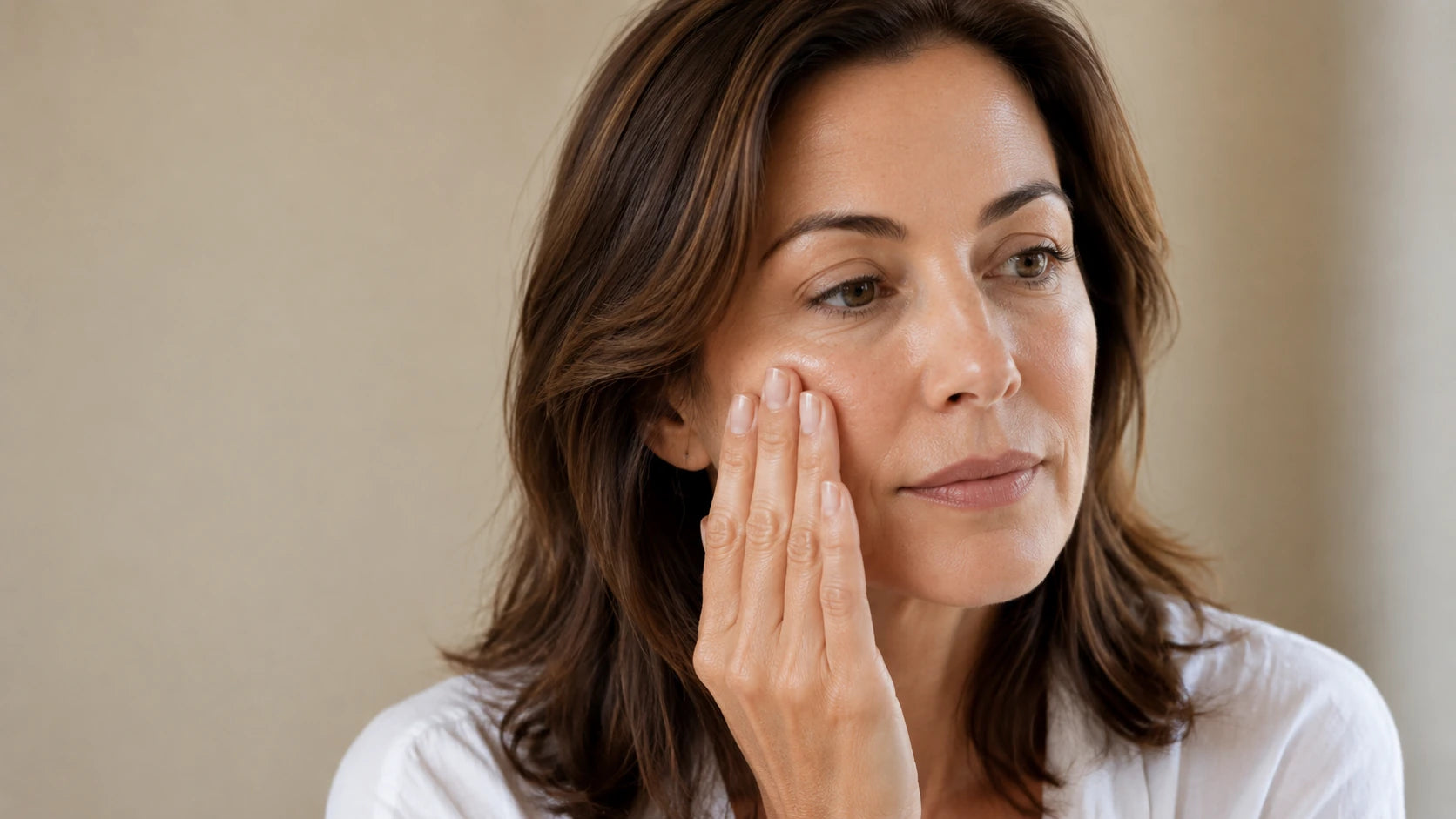 A woman applying a small amount of serum to her cheek at home, representing the Truth Treatment Systems hydrate, repair and protect step