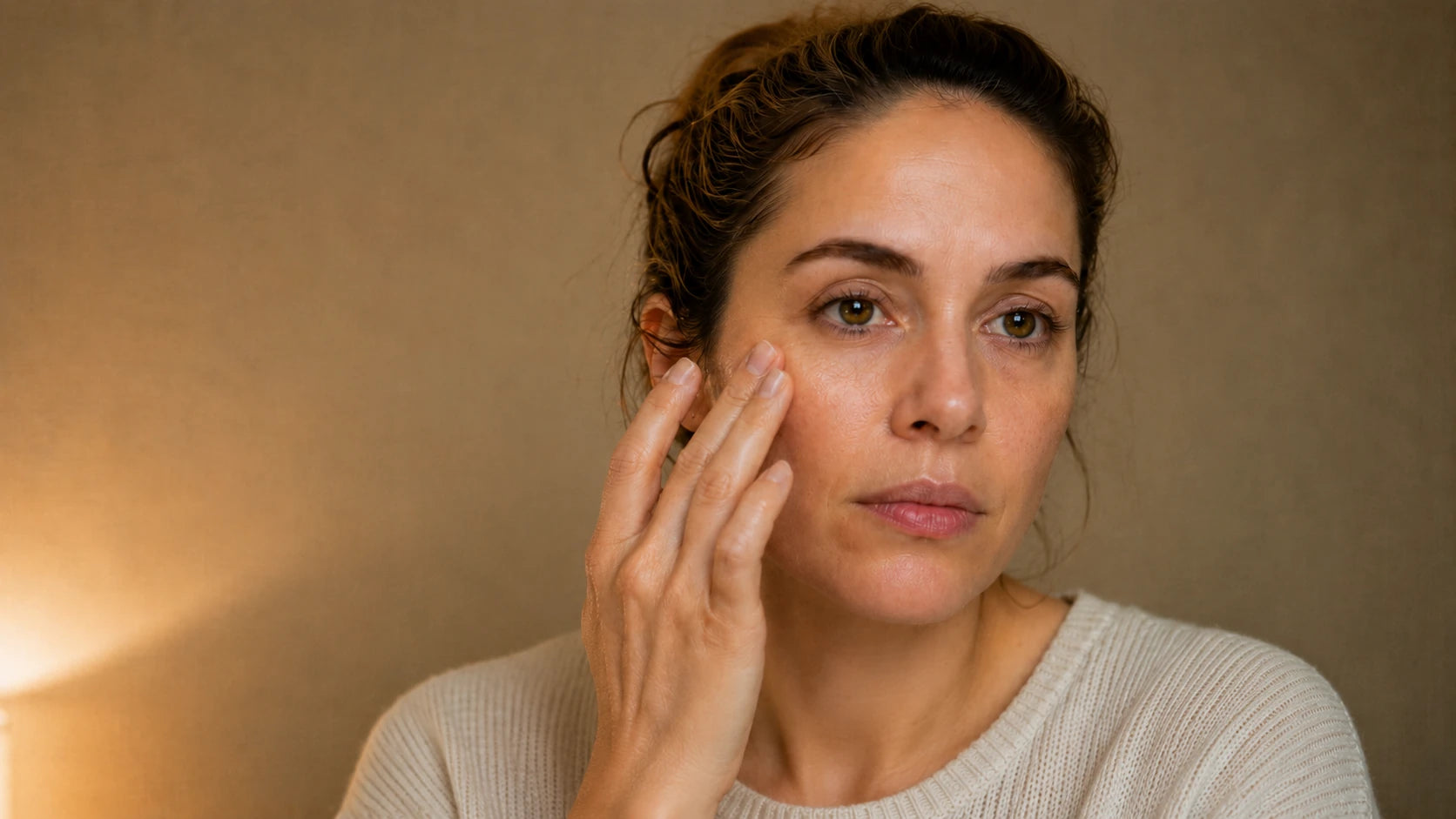 A woman precisely applying a small amount of retinol treatment under her eye at home, representing Truth Treatment Systems targeted treatments